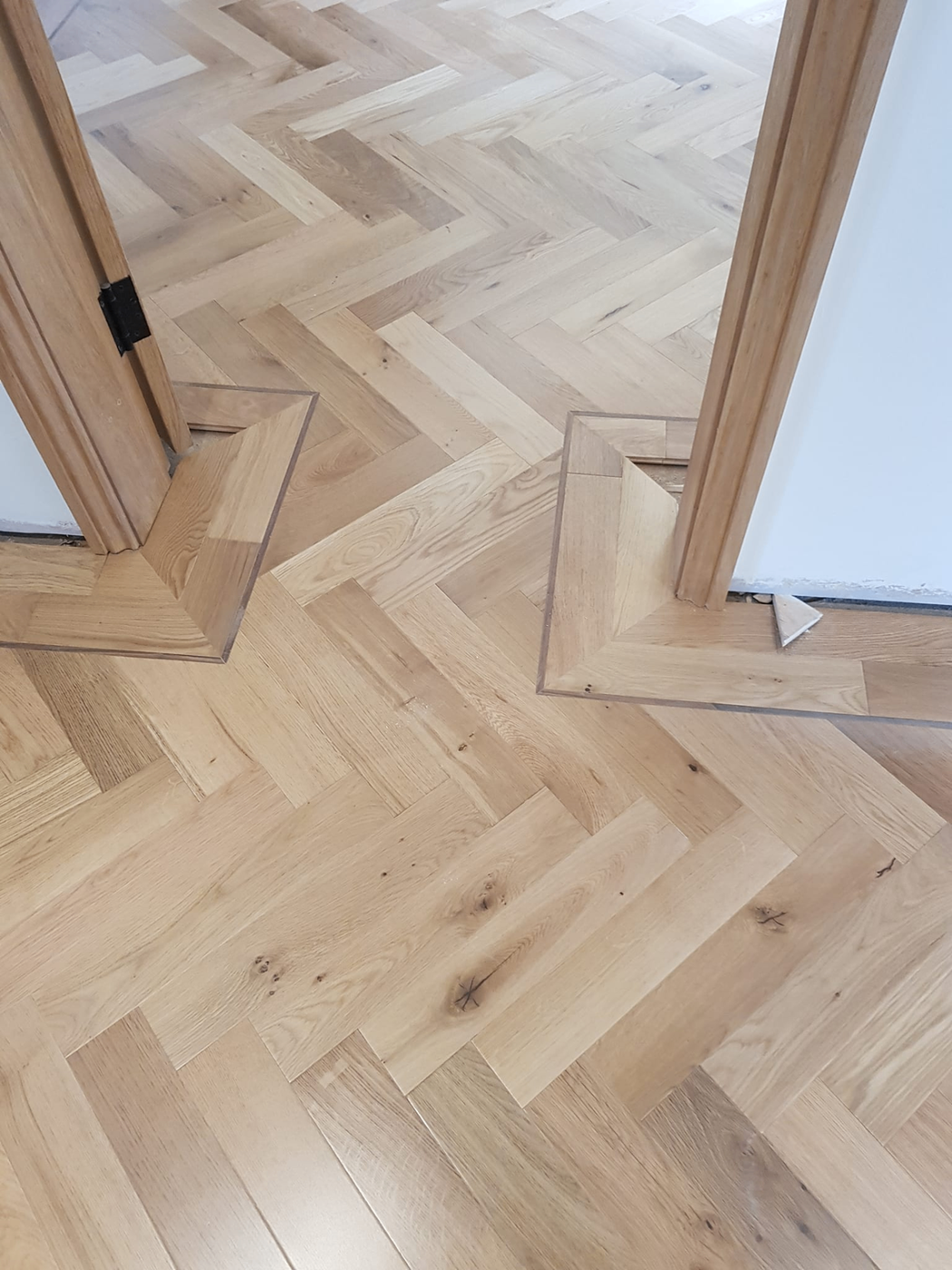 Precision herringbone timber flooring set-out at doorway
